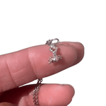 Small Sterling Bug pendant on a finger tip